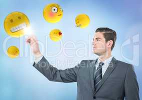 Business man pointing at emojis against blue background