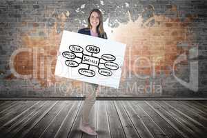 Smiling woman holding billboard with chart while standing against brick wall