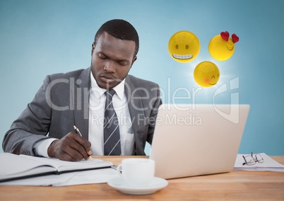 Business man working at desk with emojis and flare against blue background