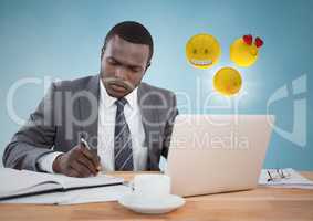 Business man working at desk with emojis and flare against blue background