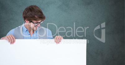 Smiling man looking at blank billboard against gray background