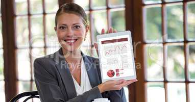 Portrait of happy businesswoman showing graphs on digital tablet