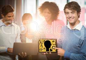 Business team with tablet showing head doodle against yellow background
