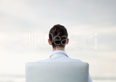 Businesswoman in chair facing backwards with bright background