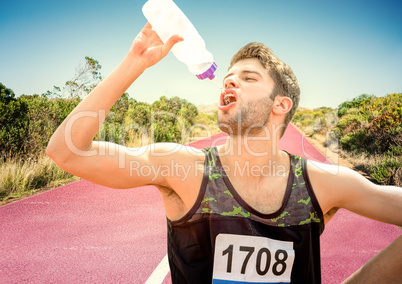 Male runner drinking on track in desert