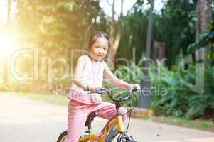 Child riding bicycle outdoor.
