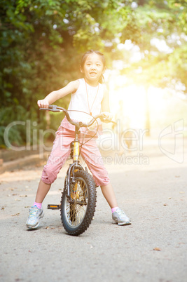 Asian child biking outdoor.