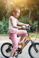 Asian child cycling outdoor.