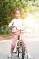 Asian child riding bikes outdoor.