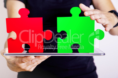 Person with tablet pc and puzzle pieces