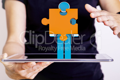 Person with tablet pc and puzzle piece