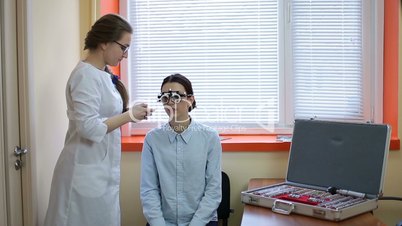 Optometrist examining patient with trial frame