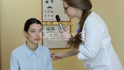 Doctor with ophthalmoscope examining patient eyes