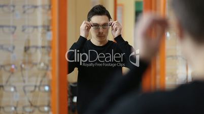 Handsome male trying eyeglasses in optical shop