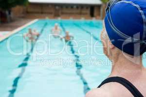 Senior woman looking at swimming pool