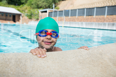 Smiling boy leaning on poolside