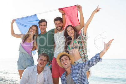Friends holding French flag on shore at beach