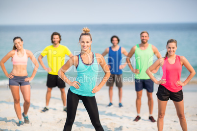 Friends standing with hands on hips at beach