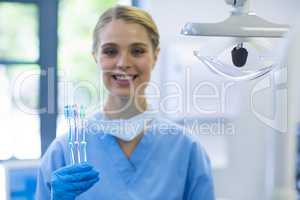 Portrait of female nurse holding toothbrushes