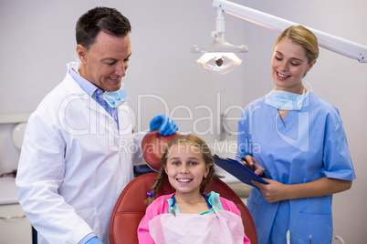 Dentist and female nurse standing beside young patient