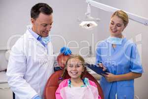 Dentist and female nurse standing beside young patient