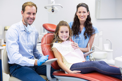 Portrait of dentist with young patient and her mother