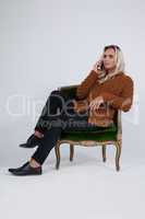 Transgender using mobile phone while sitting on chair