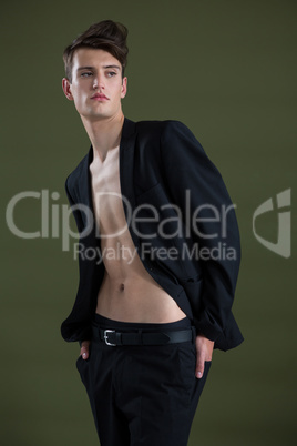 Androgynous man posing against green background