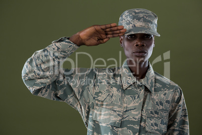 Androgynous man in camouflage uniform saluting