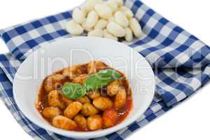 Close up of gnocchi pasta in bowl on napkin