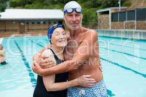 Senior couple embracing each other at poolside