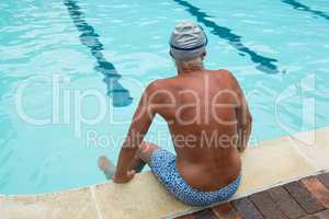 Senior man sitting at poolside