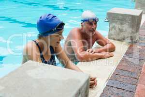 Senior man interacting with woman at poolside