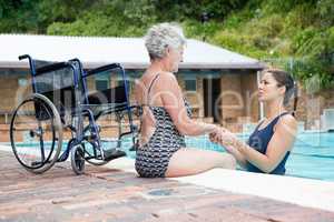 Swim coach consoling a disabled senior woman