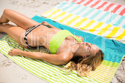 Young woman relaxing on towel at beach