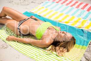 Young woman relaxing on towel at beach