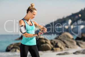 Woman with smartphone on armband listening music