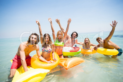 Cheerful friends enjoying on inflatable rings and pool rafts