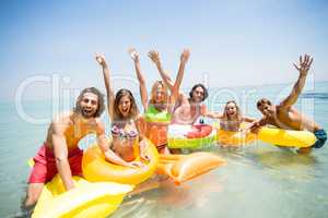 Cheerful friends enjoying on inflatable rings and pool rafts