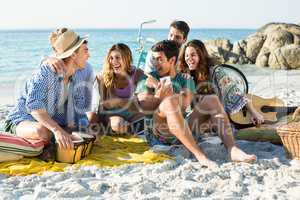 Friends laughing while sitting on shore
