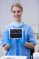 Portrait of smiling nurse holding digital tablet