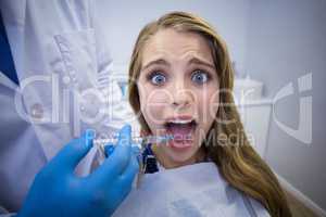 Dentist giving anesthesia to female patient