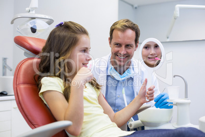Smiling young patient looking in the mirror in dental clinic