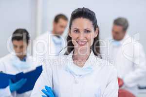 Smiling dentist standing with arms crossed