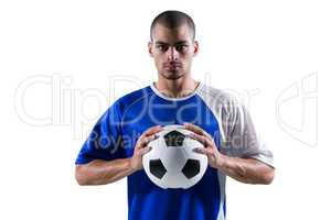 Portrait of football player holding football with both hands