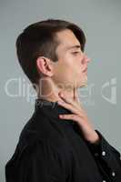 Androgynous man touching his neck
