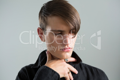 Androgynous man posing against grey background