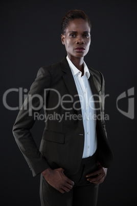 Androgynous man in suit posing against grey background