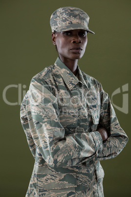 Androgynous man in camouflage uniform standing with his arms crossed