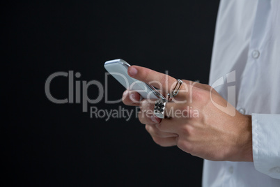 Androgynous man using mobile phone against black background